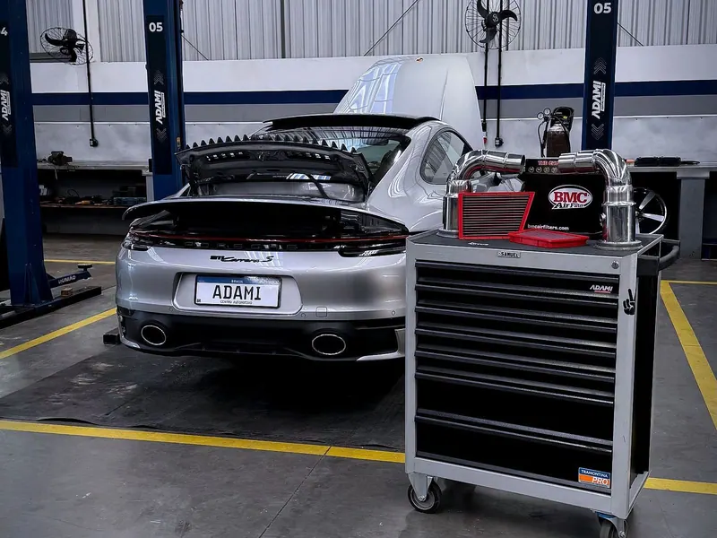 Porsche no box de serviço com carrinho de ferramentas